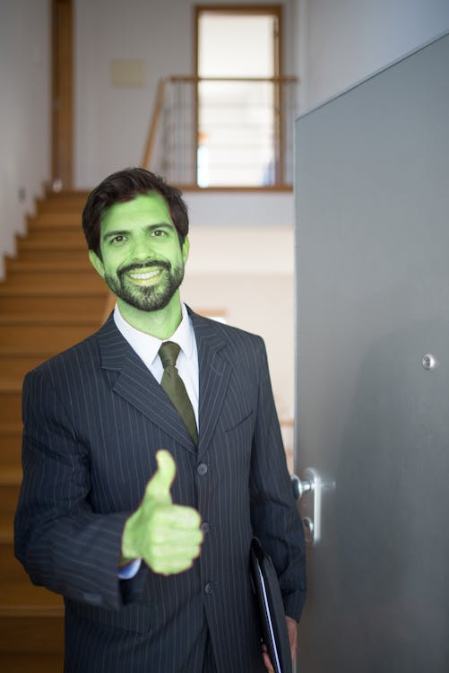 Green man giving thumbs-up sign.